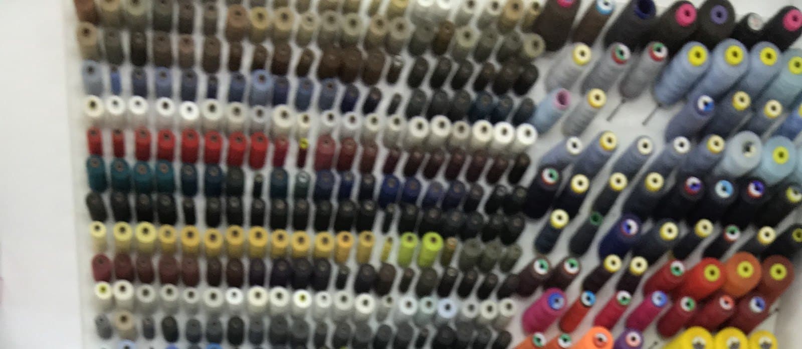 Bobine de ață colorate pe peretele atelierului